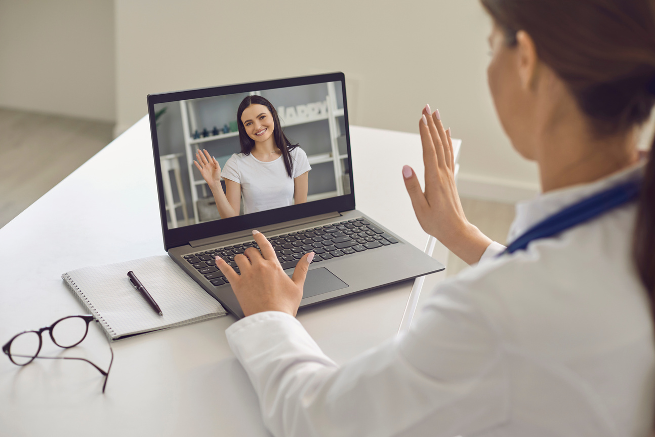 Woman Patient Greeting Her Doctor Online from Laptop Screen during Videocall on Laptop